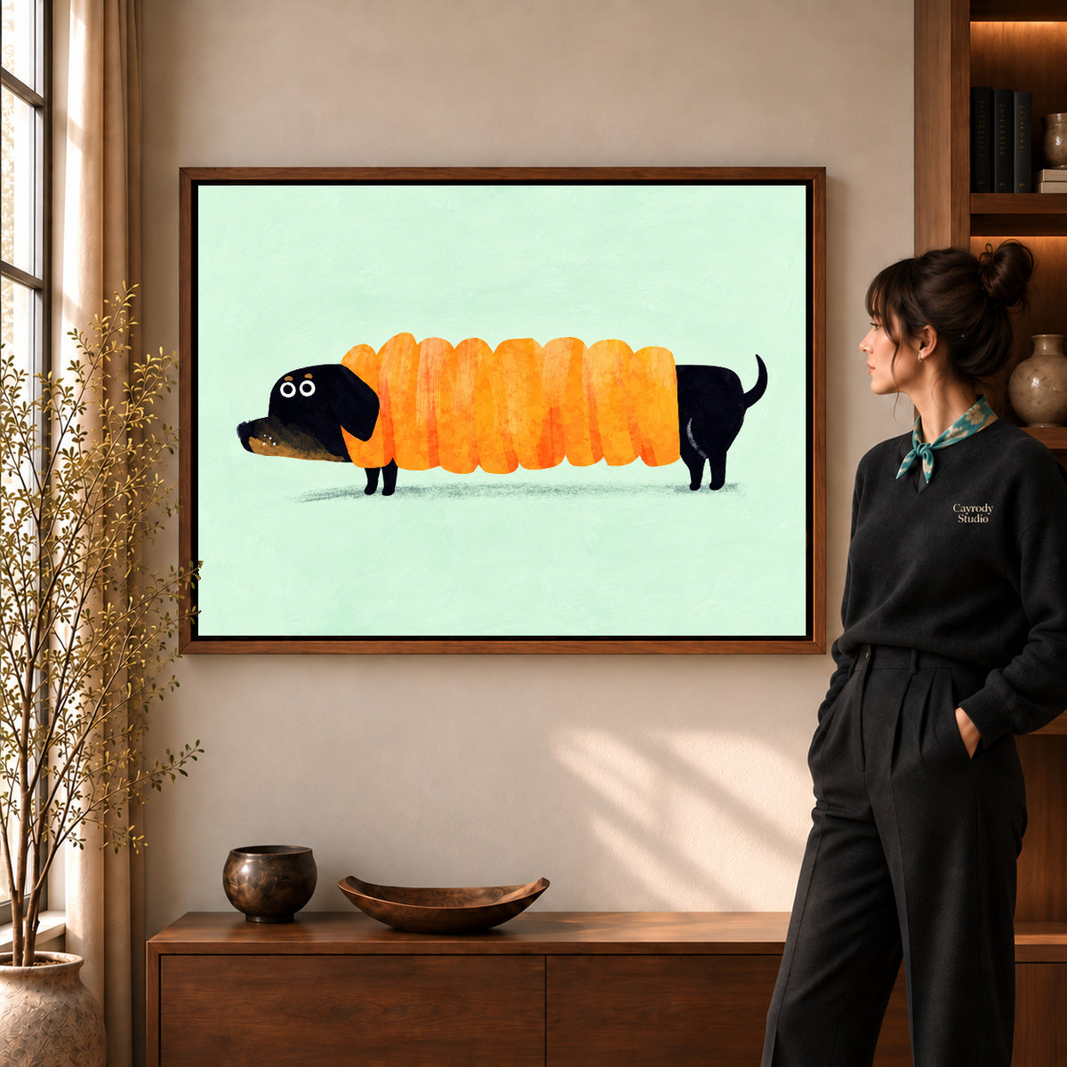 accordion dachshund canvas art in a walnut frame beside a standing woman and wooden console.