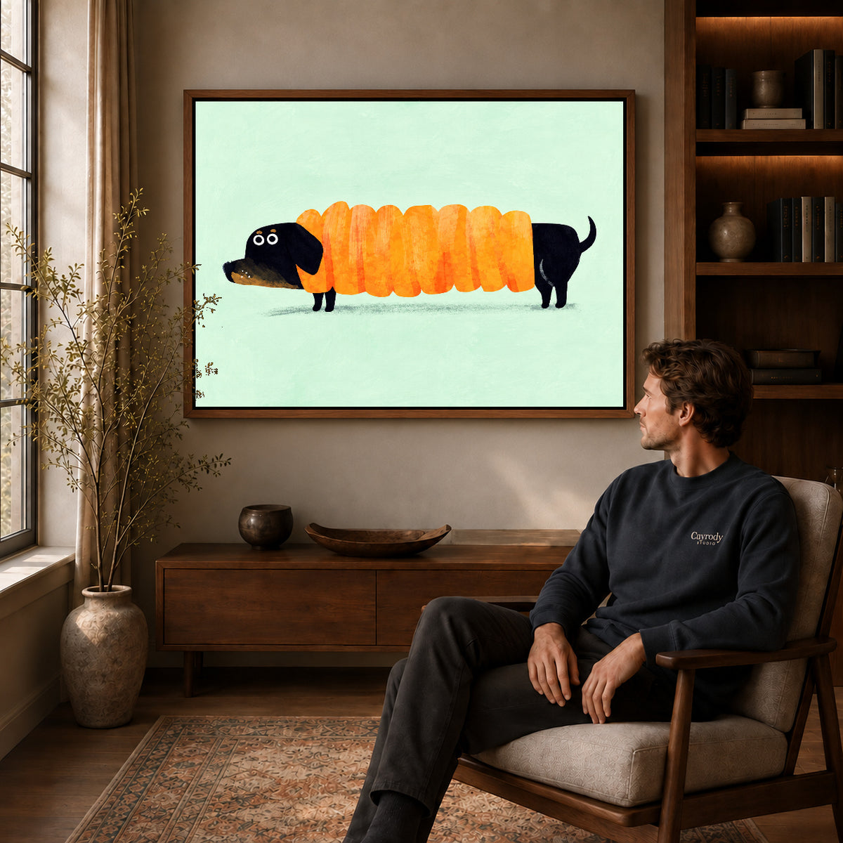 accordion dachshund canvas art in a walnut frame above a console beside a seated man.