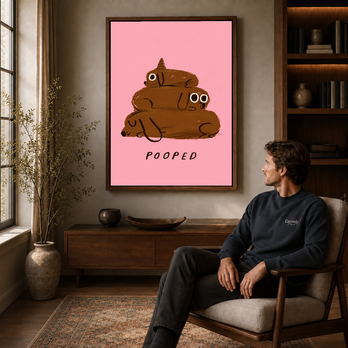 pooped puppy stack canvas art in a walnut frame above a console beside a seated man.