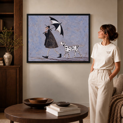 umbrella walk companions canvas art in a black frame beside a woman and round wooden table.
