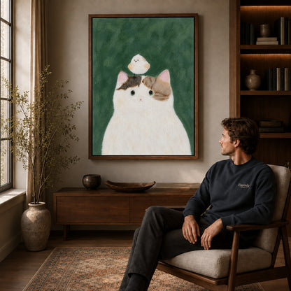 cat bird gentle friendship canvas art in a walnut frame above a console beside a seated man.