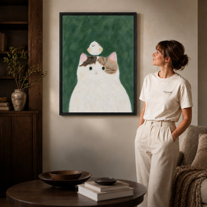 cat bird gentle friendship canvas art shown in the black frame option against a softly lit wall.