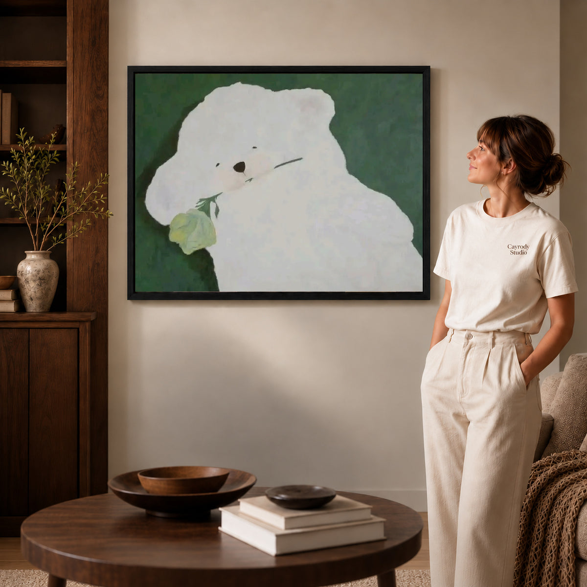 rose bearing puppy canvas art in a black frame beside a woman and round wooden table.