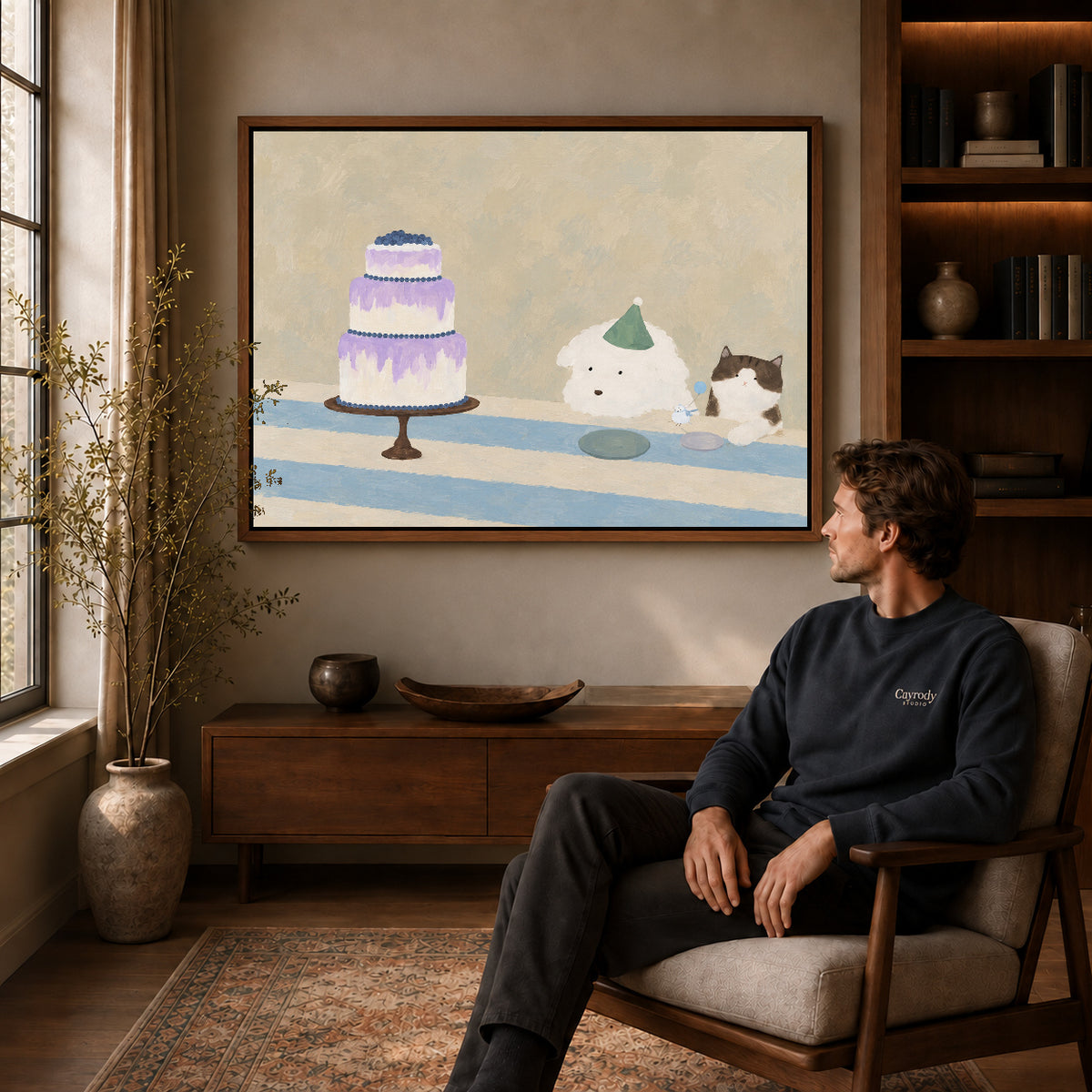 cake party companions canvas art in a walnut frame above a console beside a seated man.