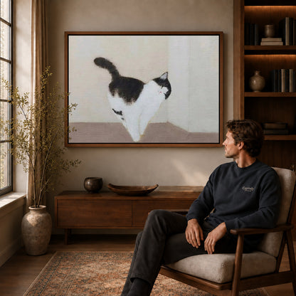 quiet cat stroll canvas art in a walnut frame above a console beside a seated man.