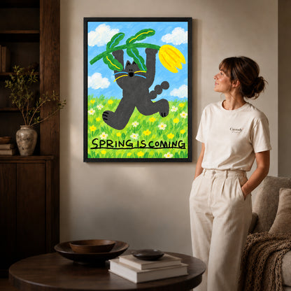 spring tulip cat canvas art in a black frame beside a woman and round wooden table.