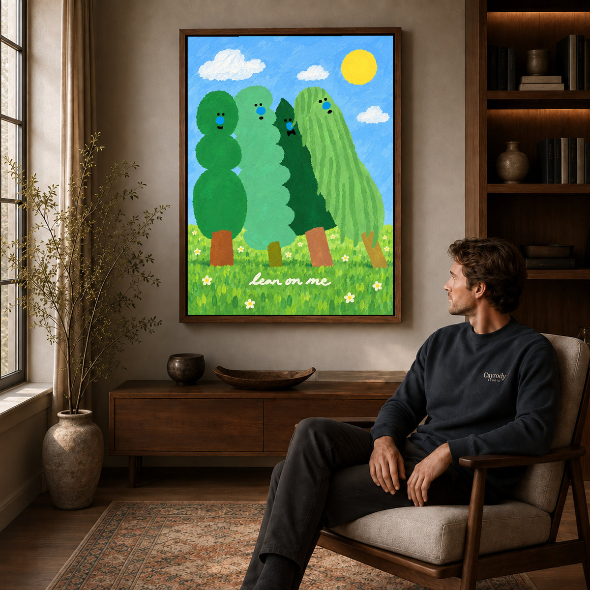 lean on me trees canvas art in a walnut frame above a console beside a seated man.