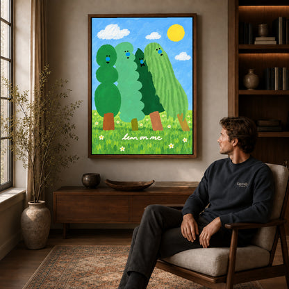 lean on me trees canvas art in a walnut frame above a console beside a seated man.