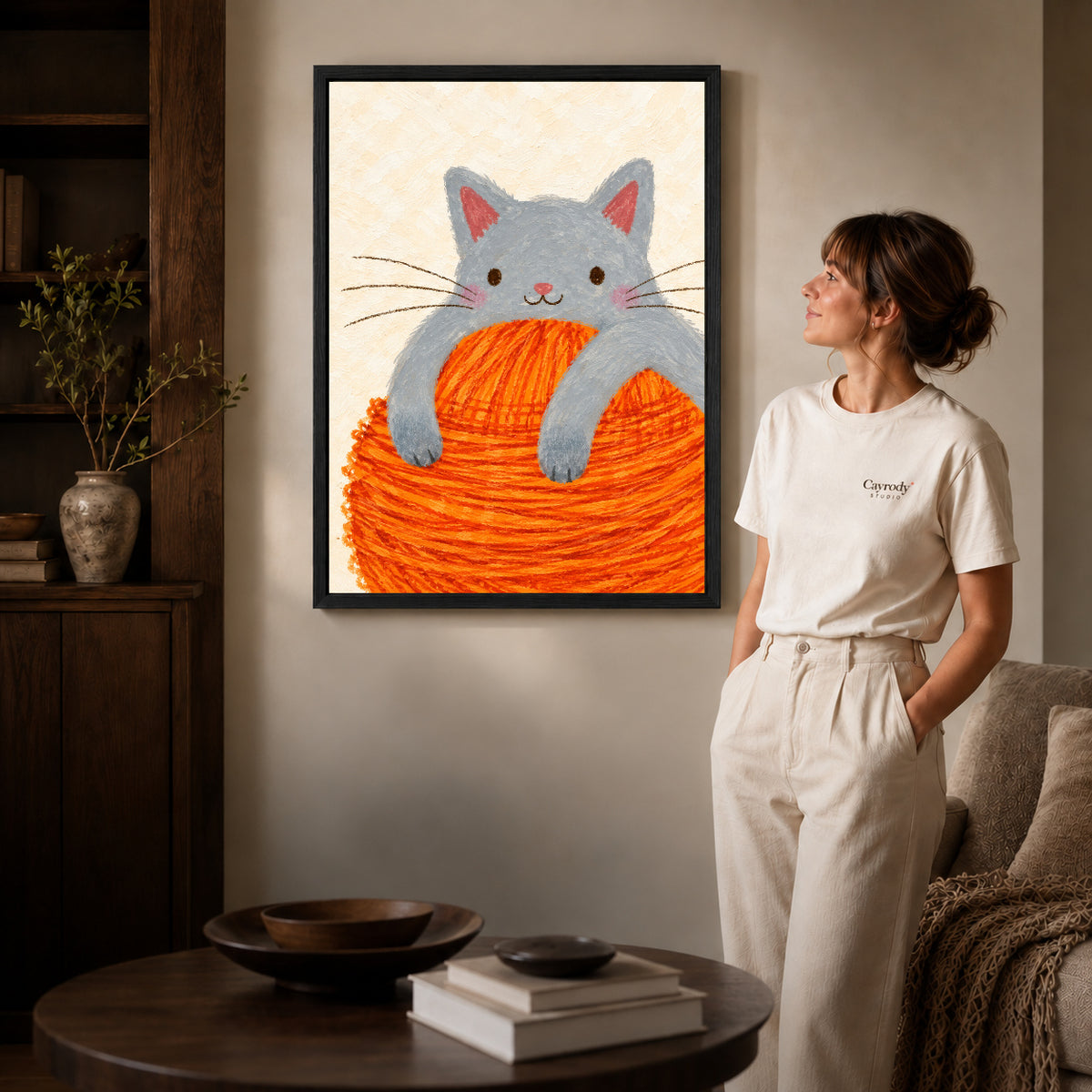 kitten yarn hug canvas art shown in the black frame option against a softly lit wall.