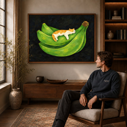 banana cat nap canvas art in a walnut frame above a console beside a seated man.