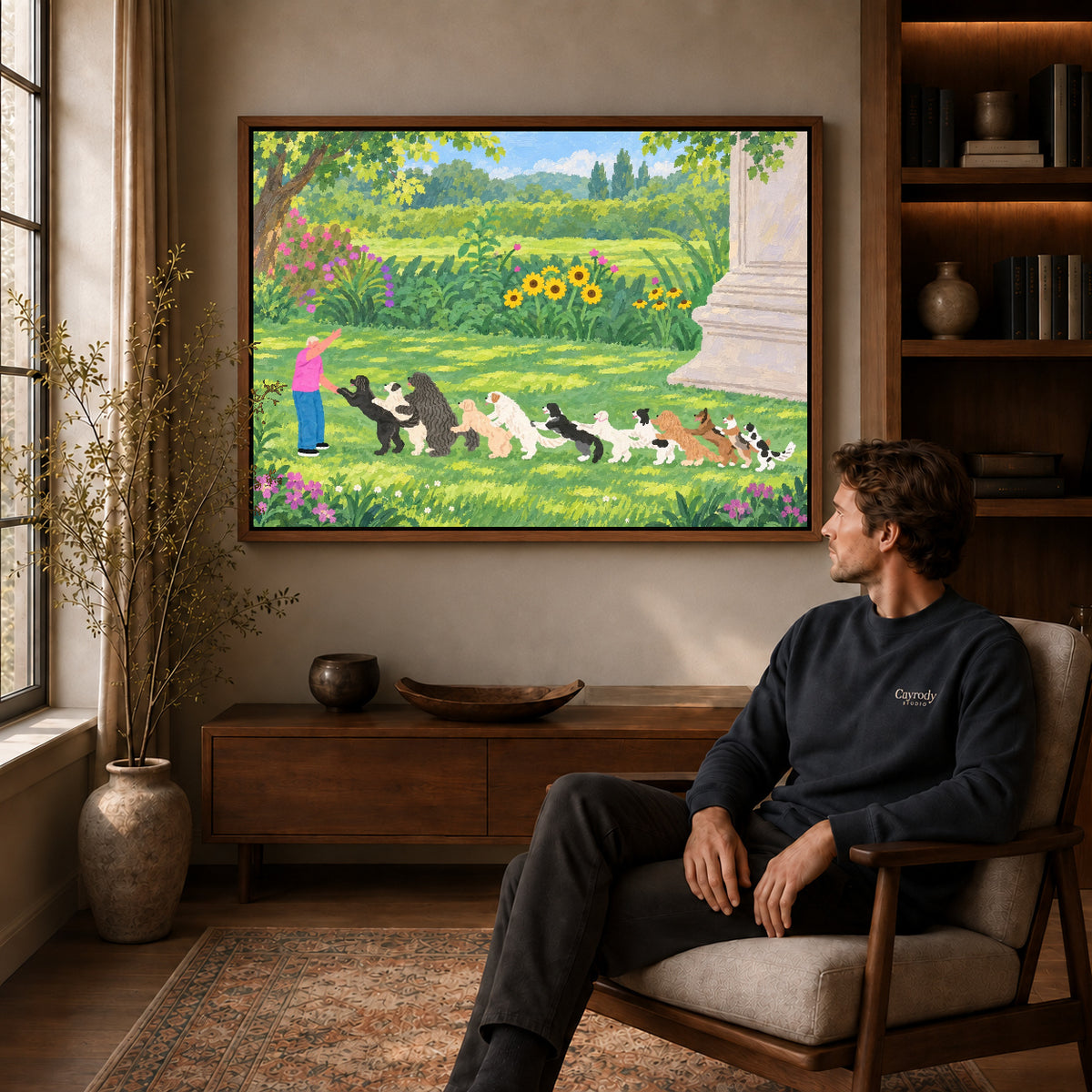 garden dog parade canvas art in a walnut frame above a console beside a seated man.