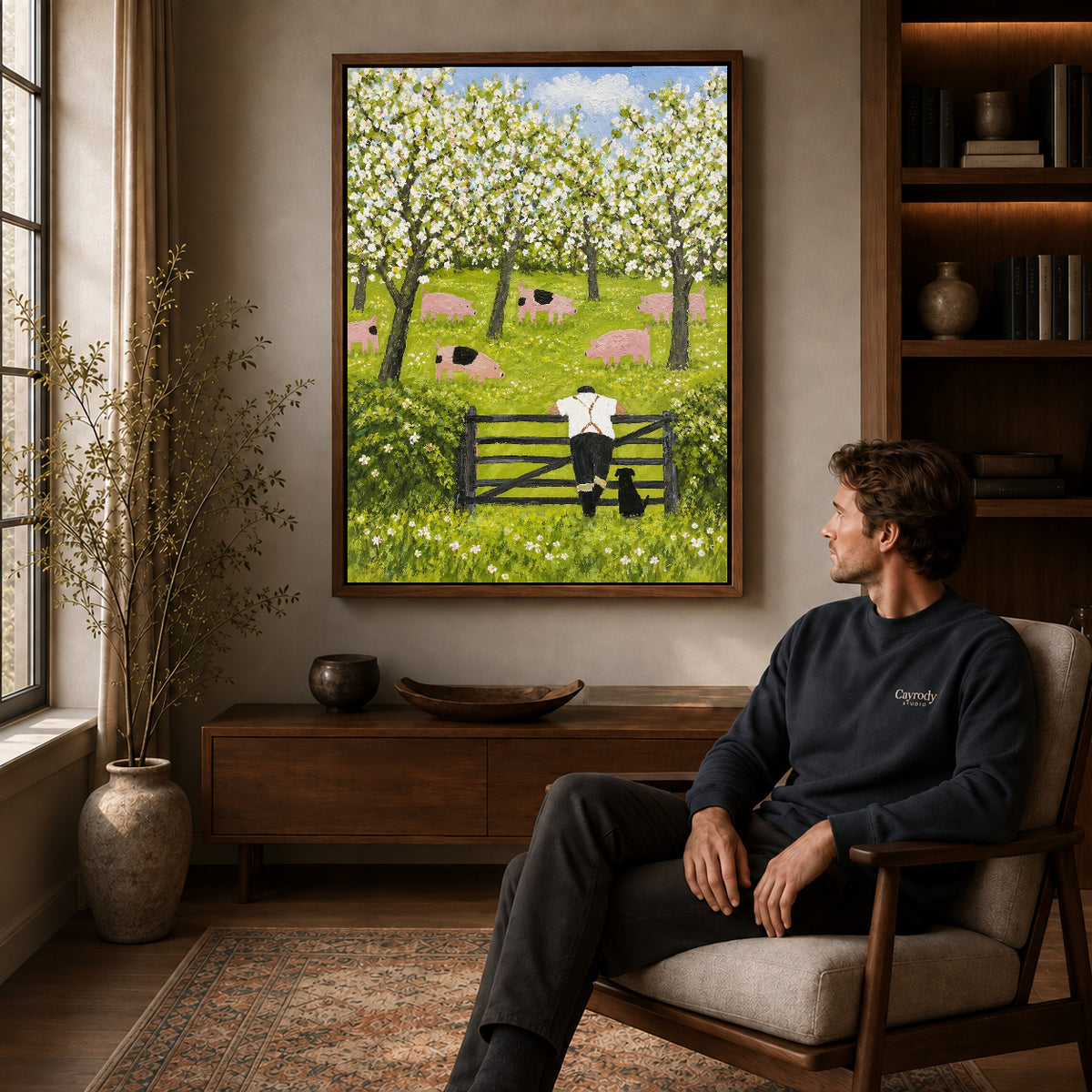 blossom orchard companions canvas art in a walnut frame above a console beside a seated man.
