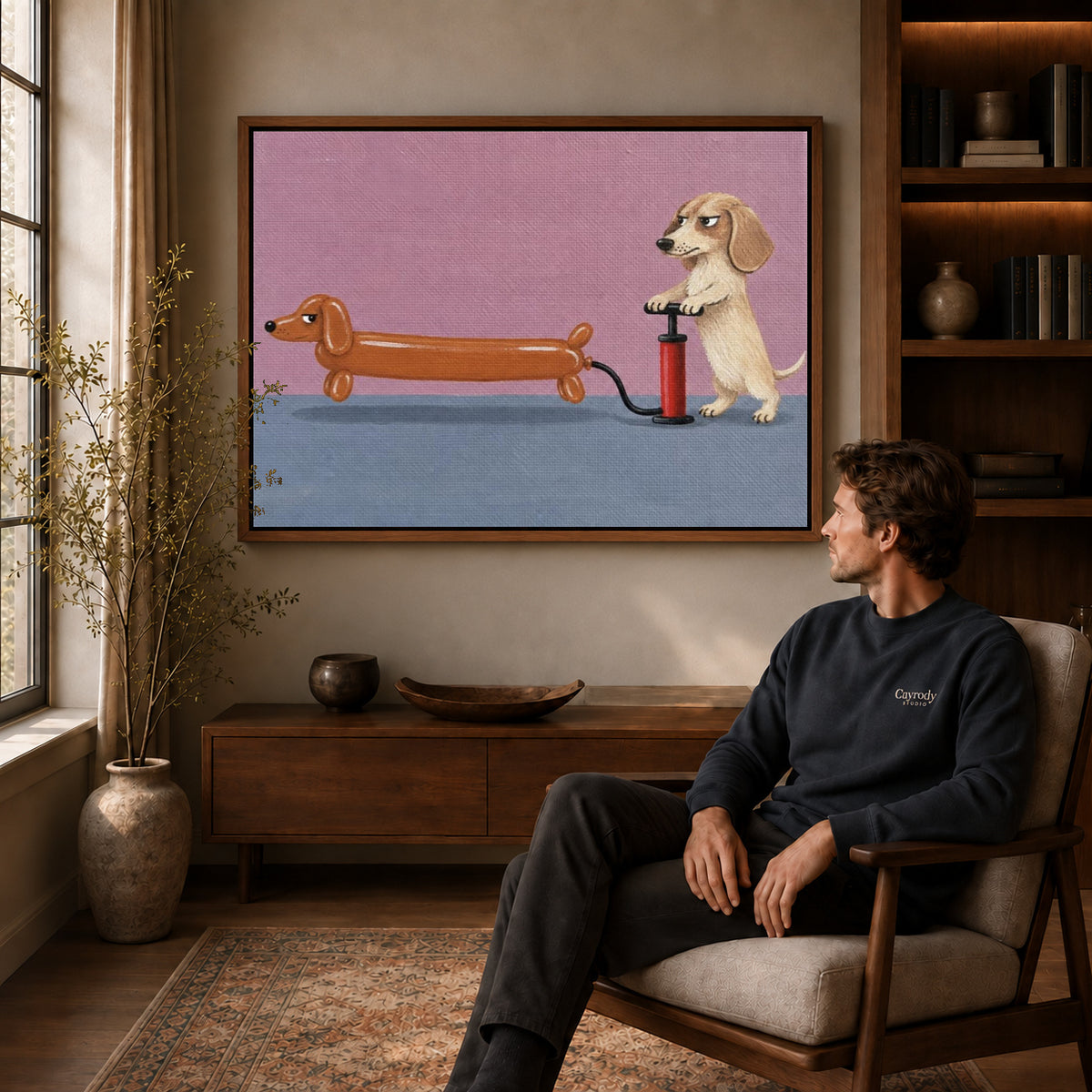 Walnut framed dachshund balloon canvas art displayed above a seated man in a wood furnished room.