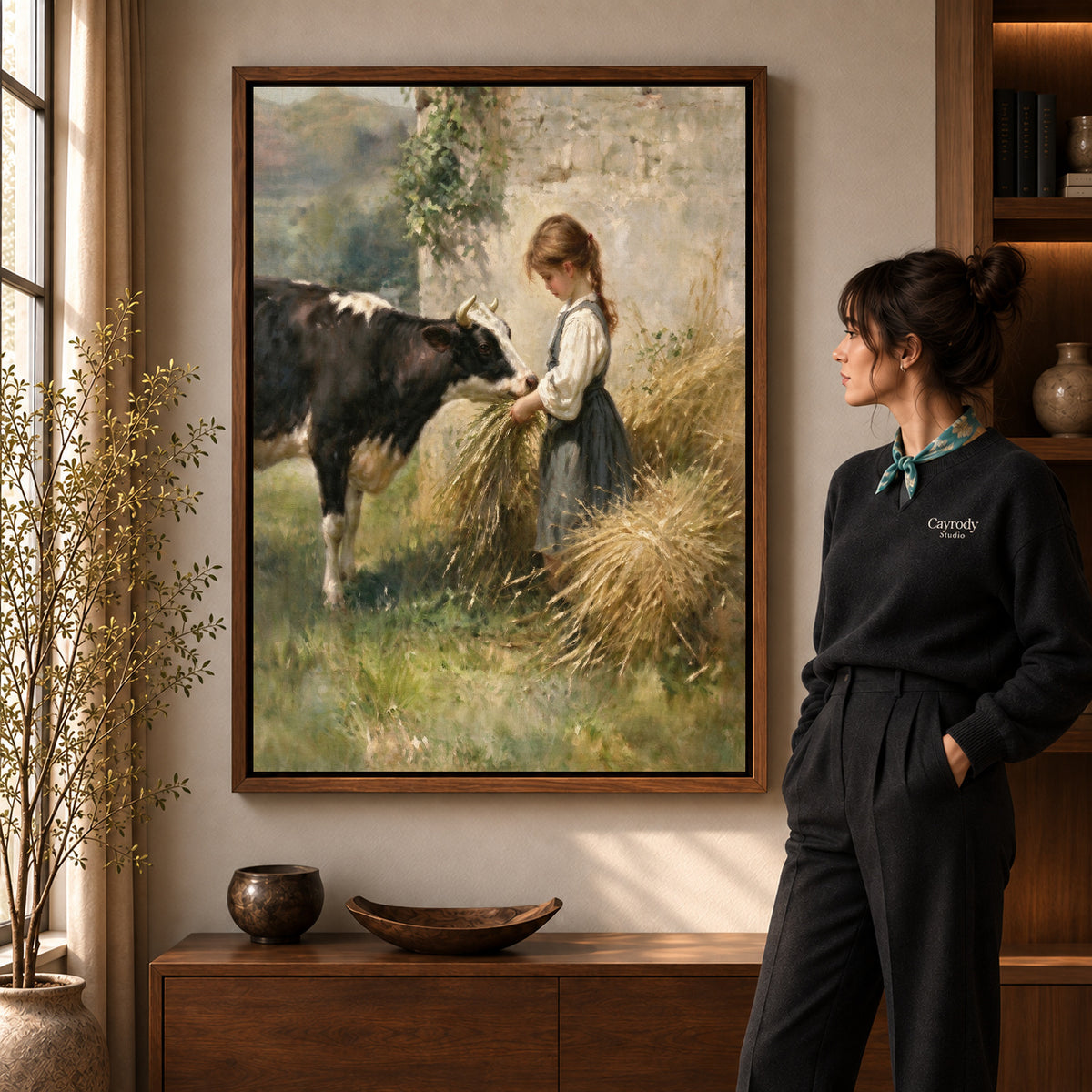 Girl feeding cow canvas art in a walnut frame beside a standing woman in a warm living room.