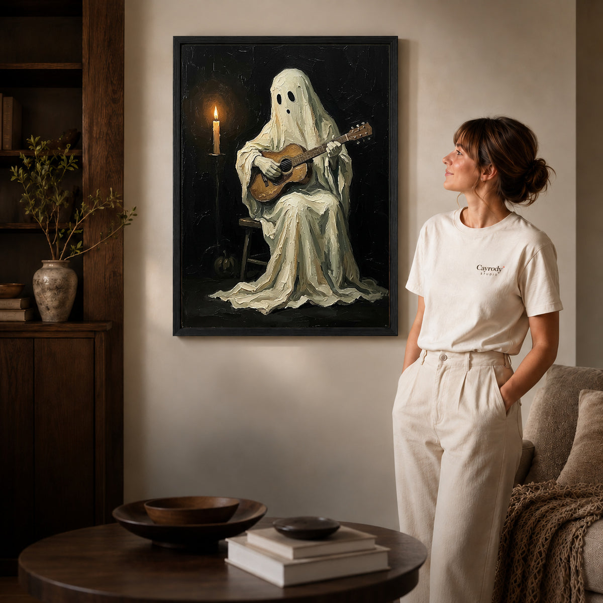 Black framed ghost guitarist canvas art displayed beside a woman in a warm neutral living room.