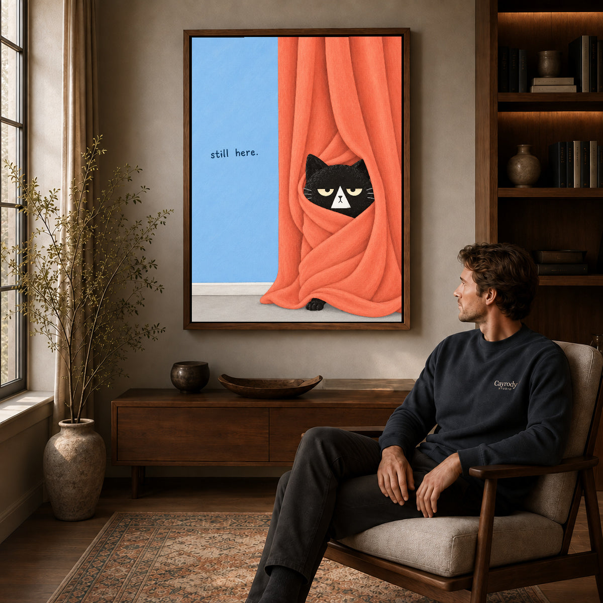 Walnut framed curtain black cat canvas art displayed above a seated man in a wood furnished room.