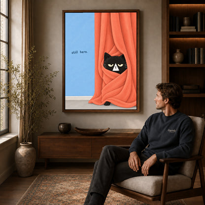 Walnut framed curtain black cat canvas art displayed above a seated man in a wood furnished room.