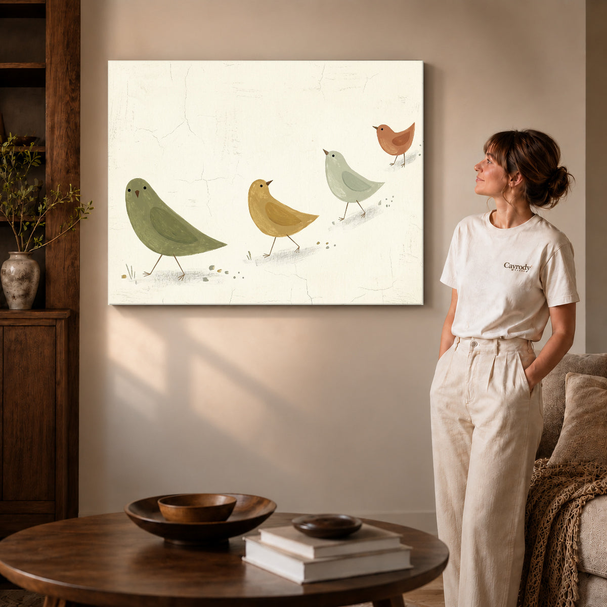 Gallery wrapped muted folk birds canvas art with naturally shaded canvas edges beside a woman wearing cream clothing.