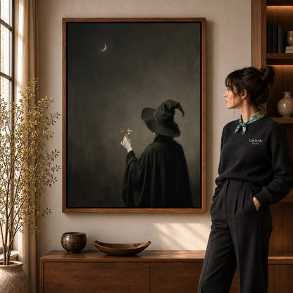Moody witch toast canvas art in a walnut frame beside a standing woman in a warm living room.