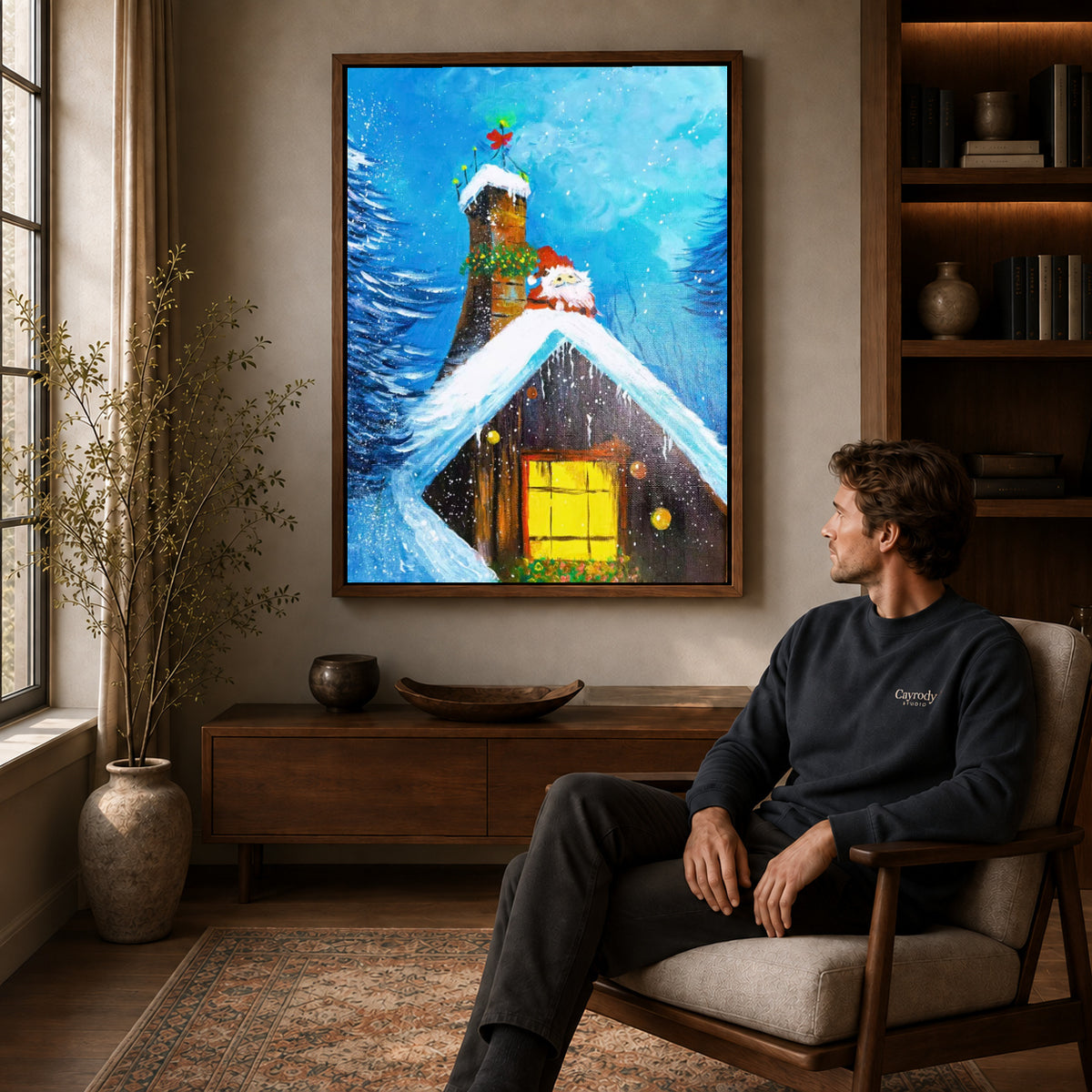 Walnut framed snowy cottage canvas art displayed above a seated man in a wood furnished living room.