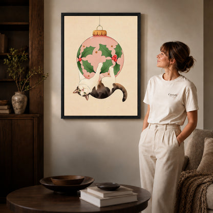Black framed hanging holiday cat canvas art displayed beside a woman in a warm neutral living room.