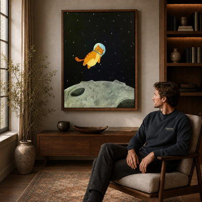 Walnut framed space kitten canvas art displayed above a seated man in a wood furnished living room.