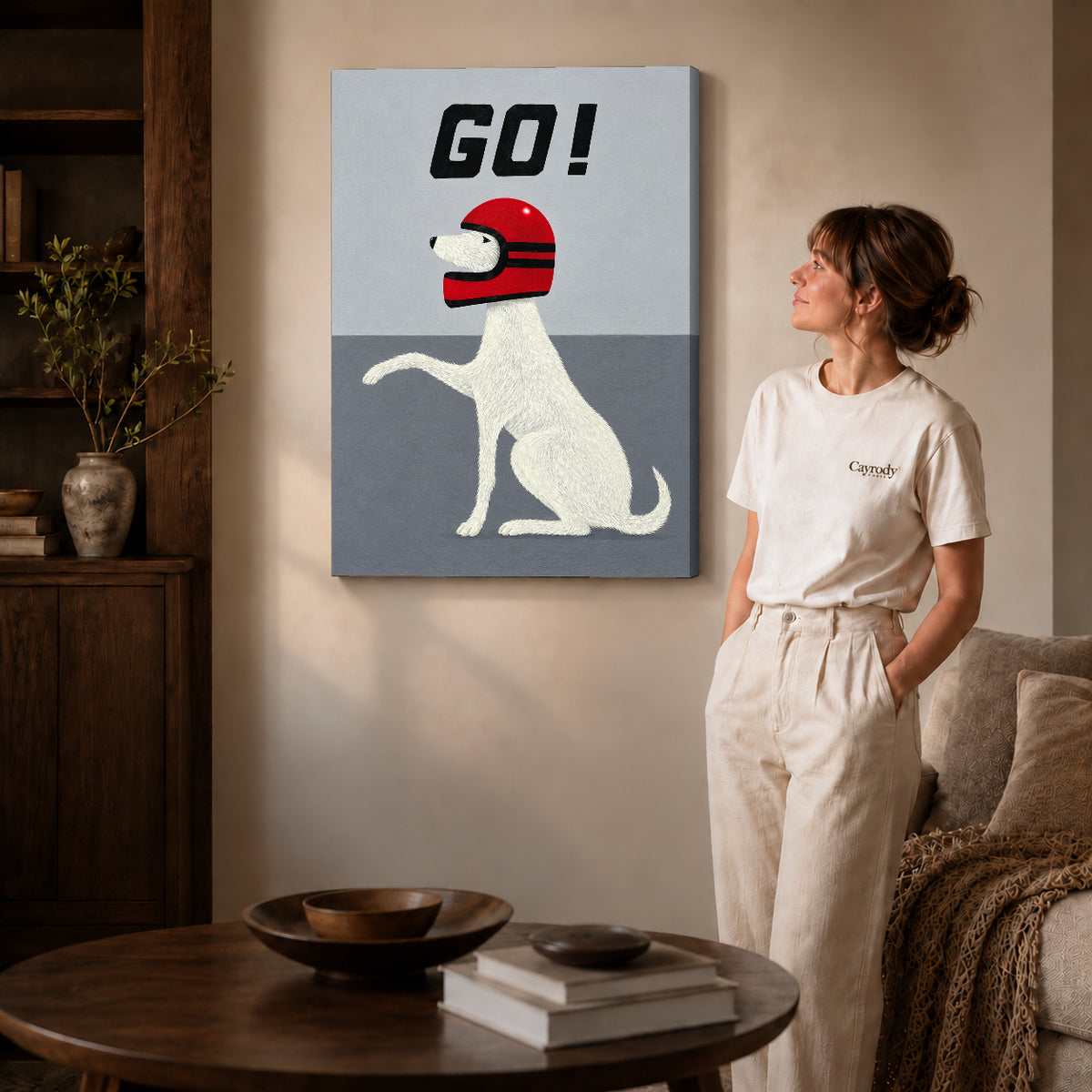 Gallery wrapped playful helmet dog artwork with shaded canvas edges beside a woman wearing cream clothing.