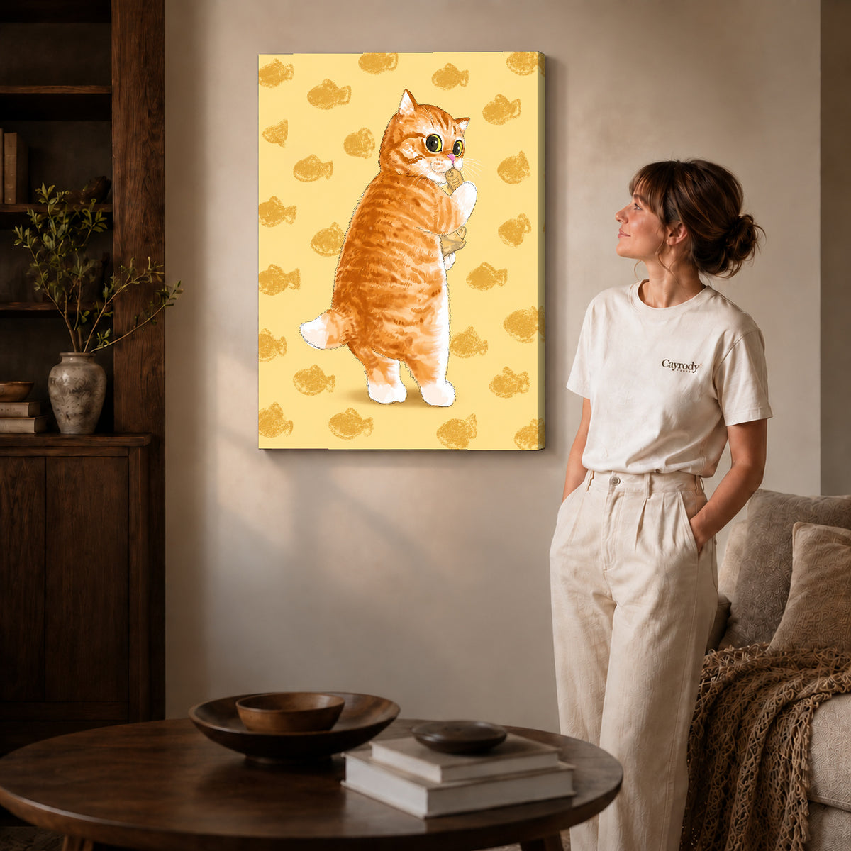 Gallery wrapped ginger kitten canvas art with naturally shaded canvas edges beside a woman wearing cream clothing.