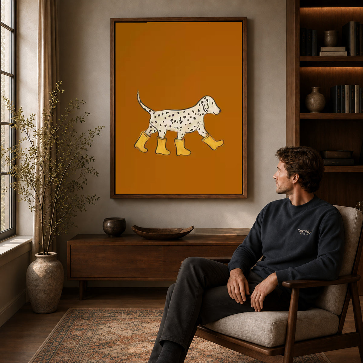 Walnut framed rain boot dalmatian canvas art displayed above a seated man in a wood furnished room.