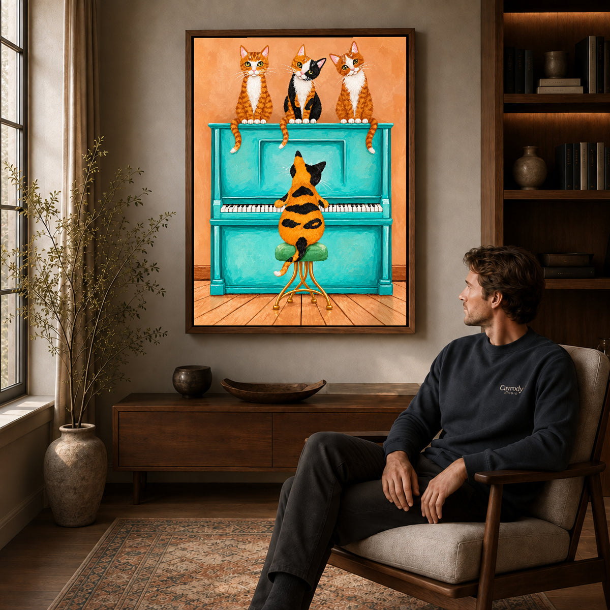 Walnut framed cat piano quartet canvas art displayed above a seated man in a wood furnished room.