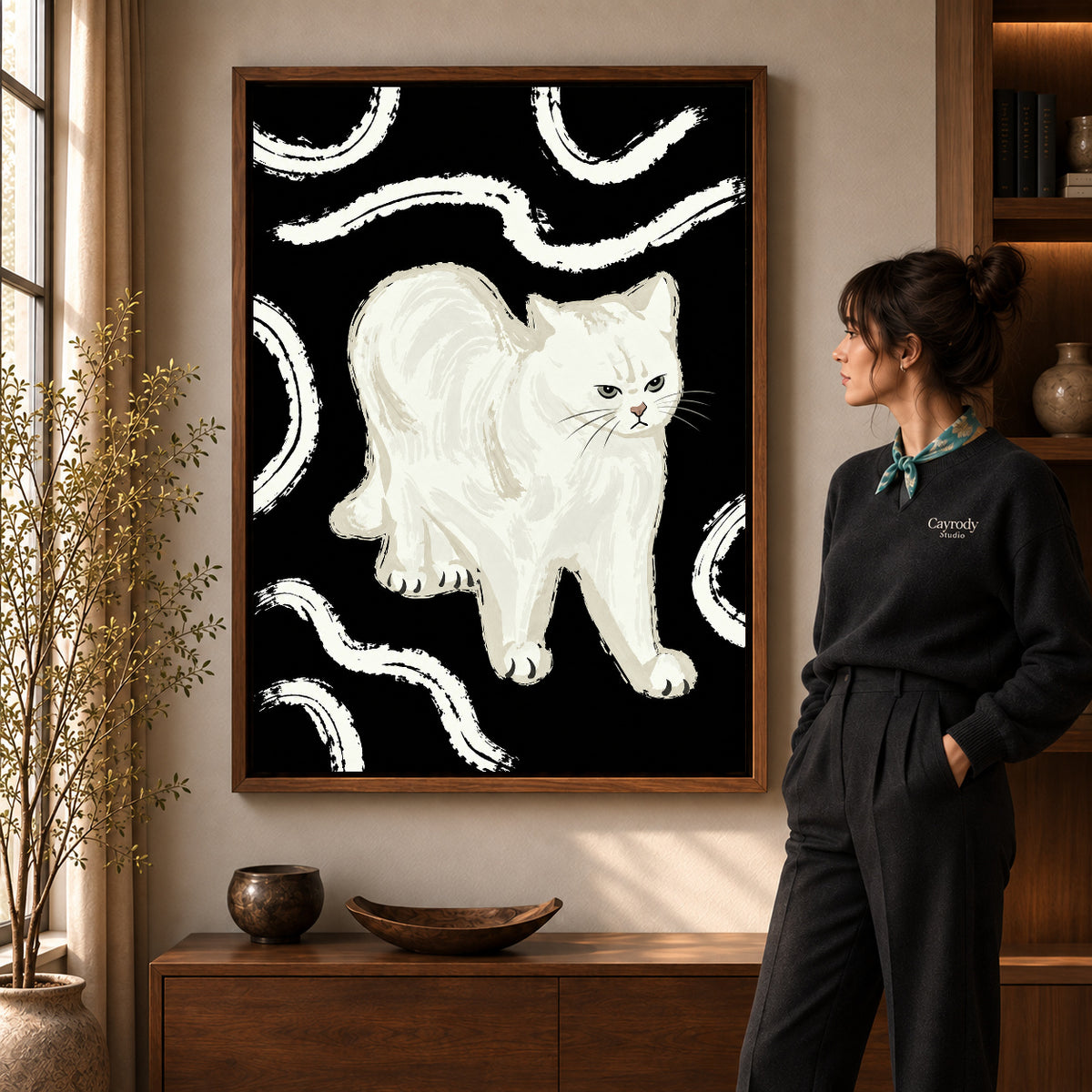 Grumpy White Cat artwork in a walnut frame beside a standing woman in a warm room.