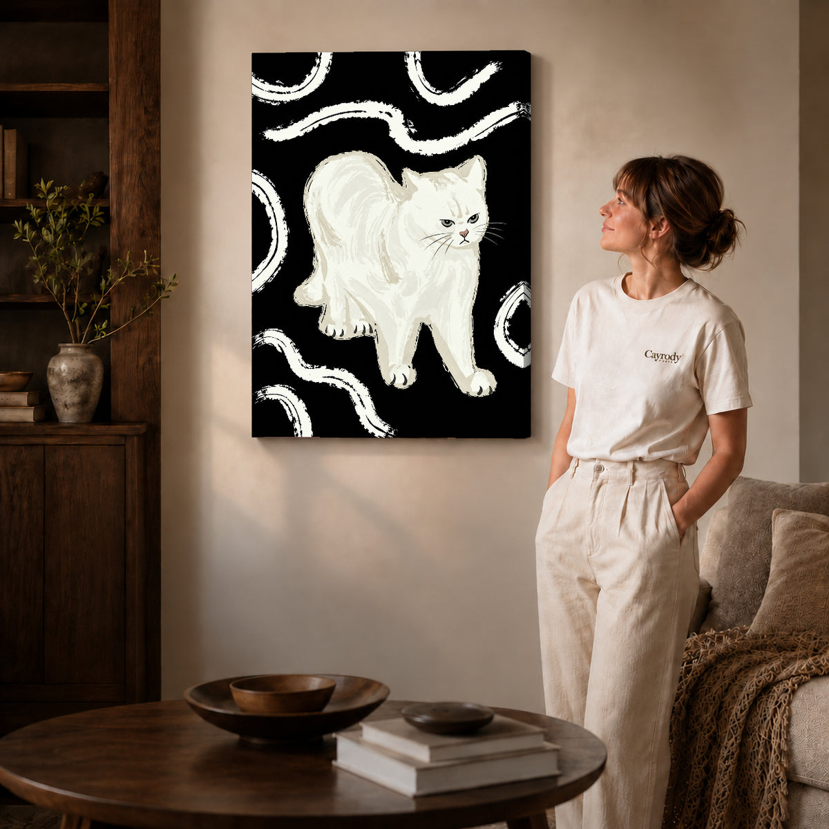 Gallery wrapped grumpy white cat artwork with shaded canvas edges beside a woman wearing cream clothing.