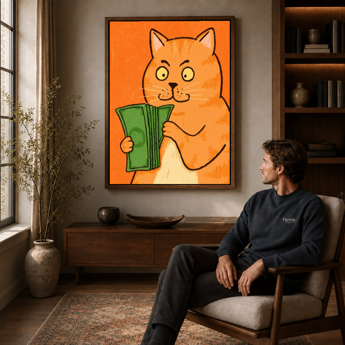 Walnut framed money cat portrait canvas art displayed above a seated man in a wood furnished room.