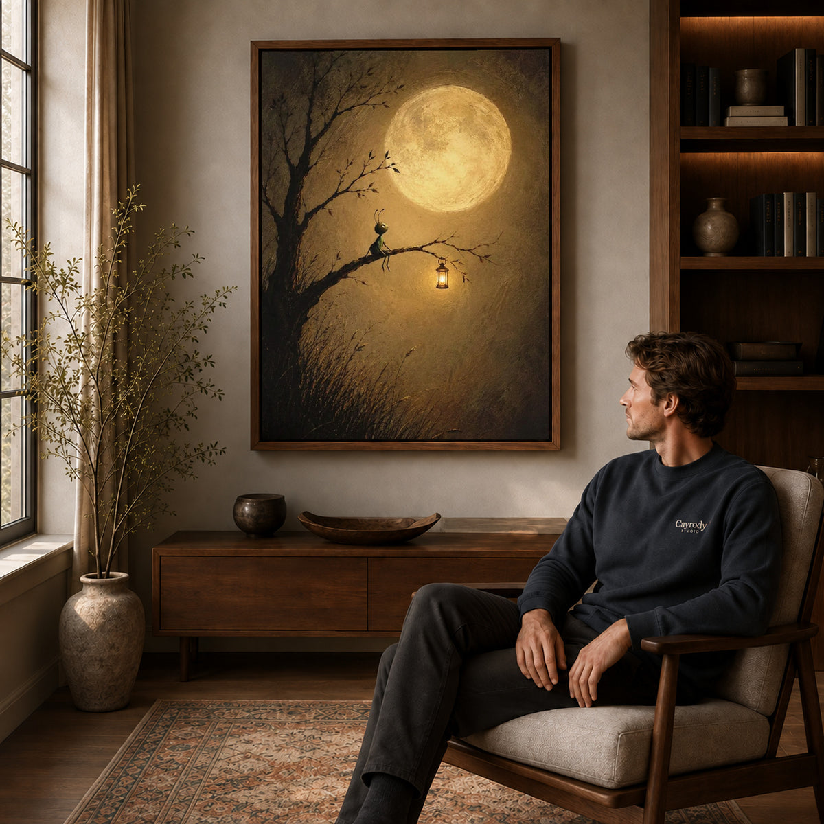 Walnut framed moonlit insect lantern canvas art displayed above a seated man in a wood furnished room.