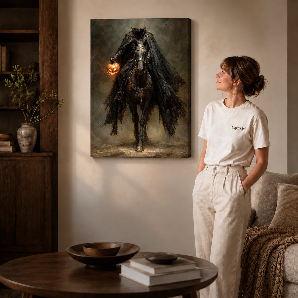 Gallery wrapped headless pumpkin rider artwork with shaded canvas edges beside a woman wearing cream clothing.