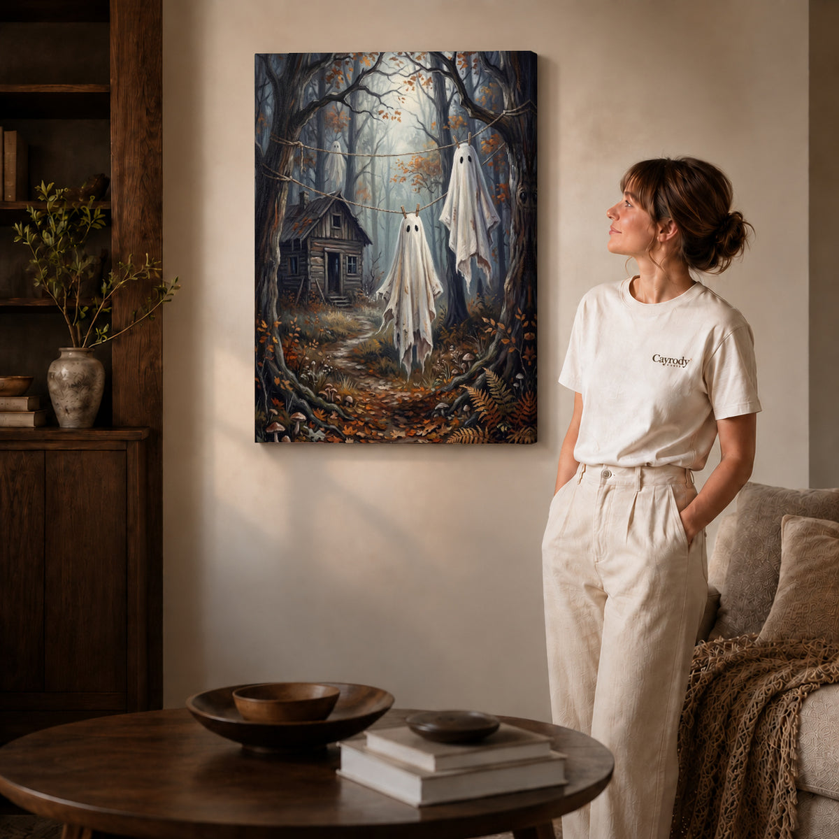 Gallery wrapped forest laundry ghosts canvas art with naturally shaded canvas edges beside a woman wearing cream clothing.