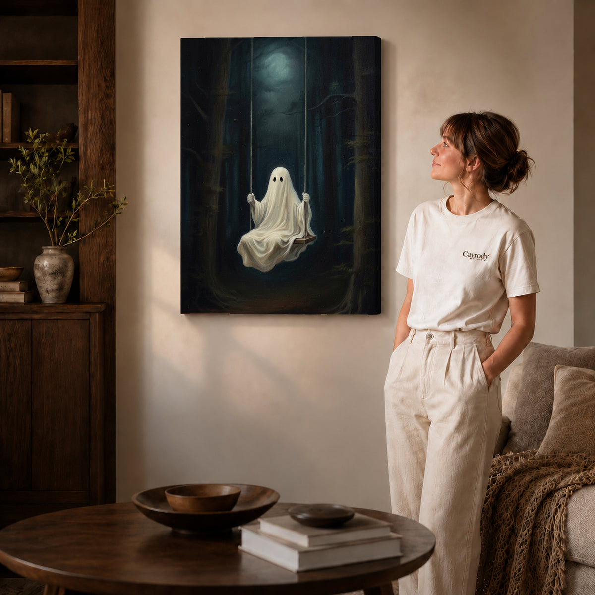 Gallery wrapped moonlit ghost swing canvas art with naturally shaded canvas edges beside a woman wearing cream clothing.