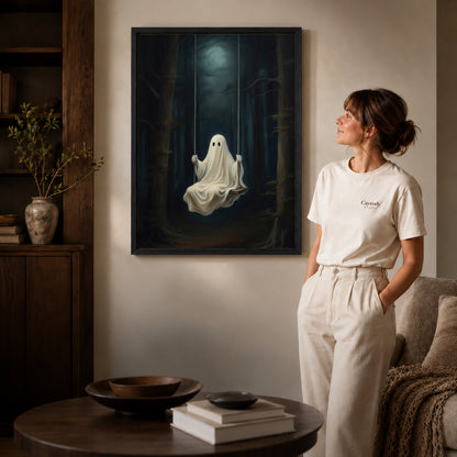 Black framed moonlit ghost swing canvas art displayed beside a woman in a warm neutral living room.