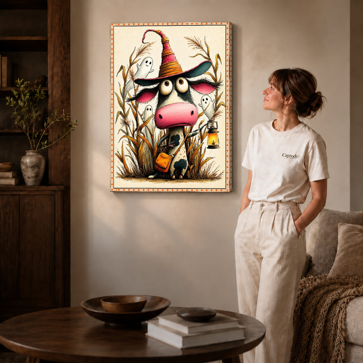 Gallery wrapped lantern witch cow artwork with shaded canvas edges beside a woman wearing cream clothing.