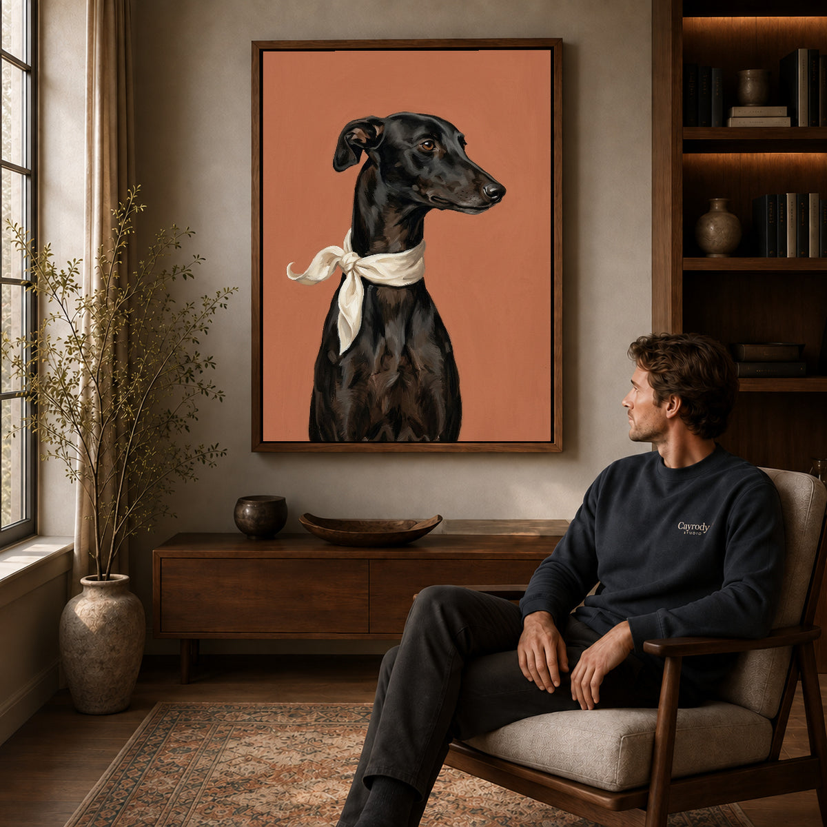 Walnut framed elegant greyhound portrait canvas art displayed above a seated man in a wood furnished room.