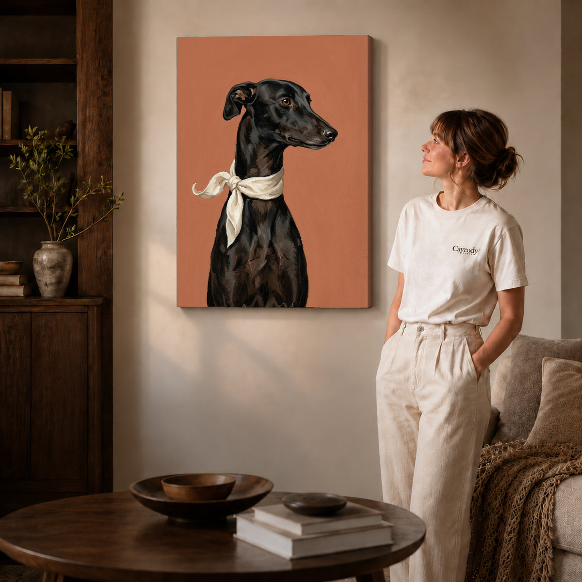 Gallery wrapped elegant greyhound portrait canvas art with naturally shaded canvas edges beside a woman wearing cream clothing.