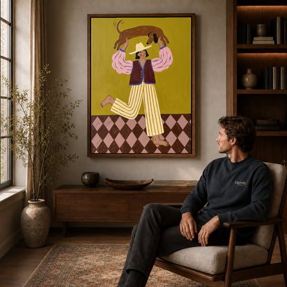 Walnut framed folk woman and dachshund canvas art displayed above a seated man in a wood furnished room.