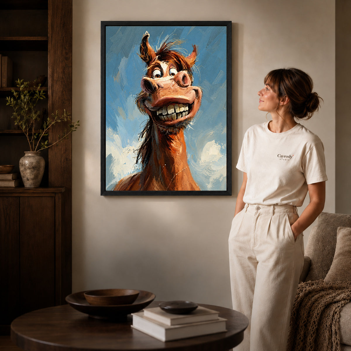 Black framed grinning horse portrait artwork beside a woman in a warm neutral living room.