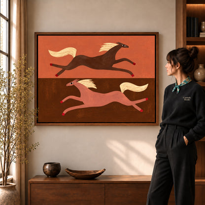 Opposite Galloping Horses artwork in a walnut frame beside a standing woman in a warm room.