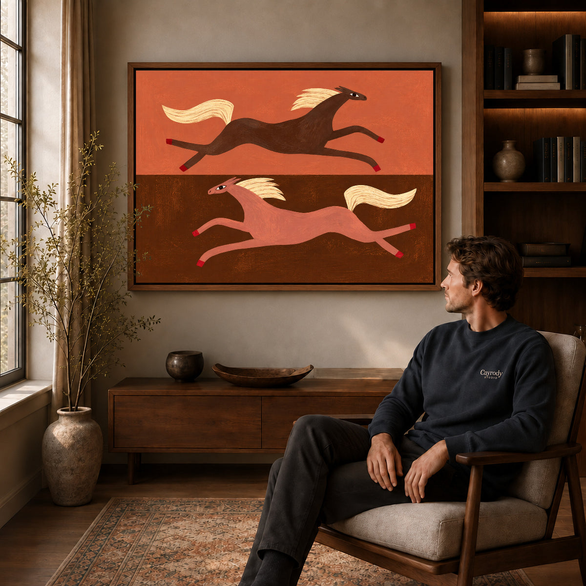 Walnut framed opposite galloping horses artwork above a seated man in a wood furnished living room.