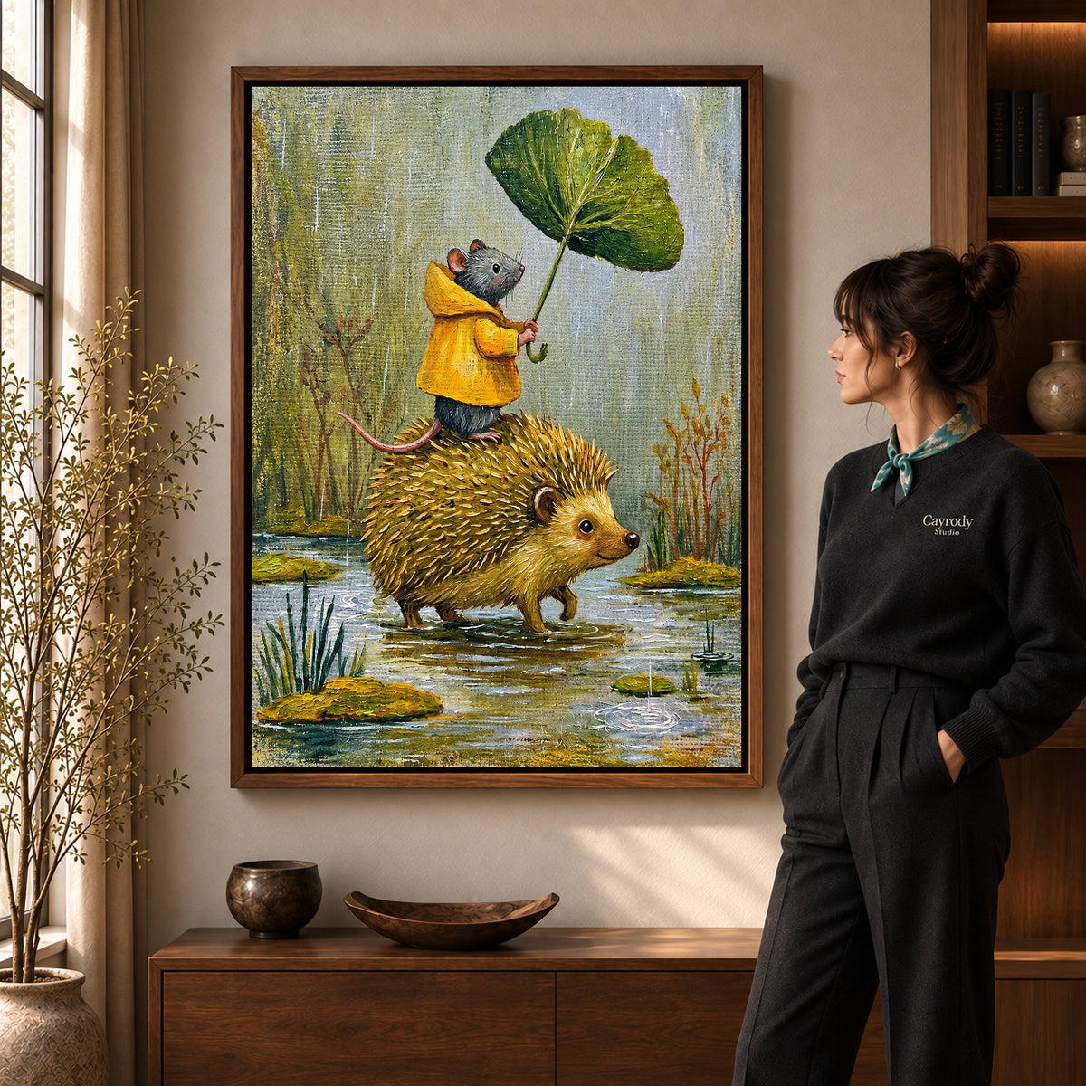 Raincoat Mouse Ride artwork in a walnut frame beside a standing woman in a warm room.