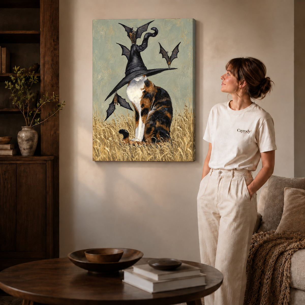 Gallery wrapped calico witch hat artwork with shaded canvas edges beside a woman wearing cream clothing.