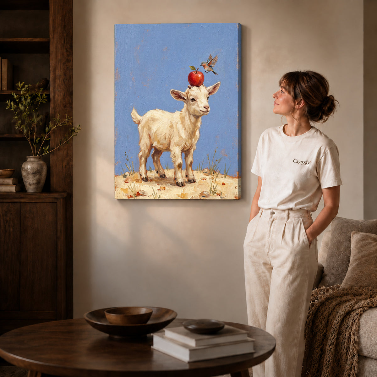 Gallery wrapped goat apple balance canvas art with naturally shaded canvas edges beside a woman wearing cream clothing.