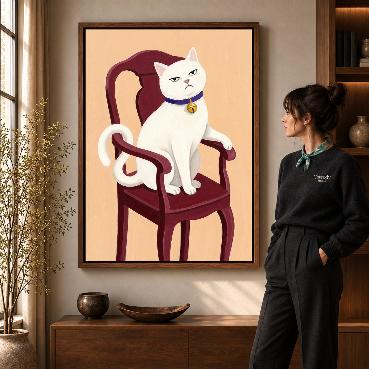 Regal White Cat artwork in a walnut frame beside a standing woman in a warm room.