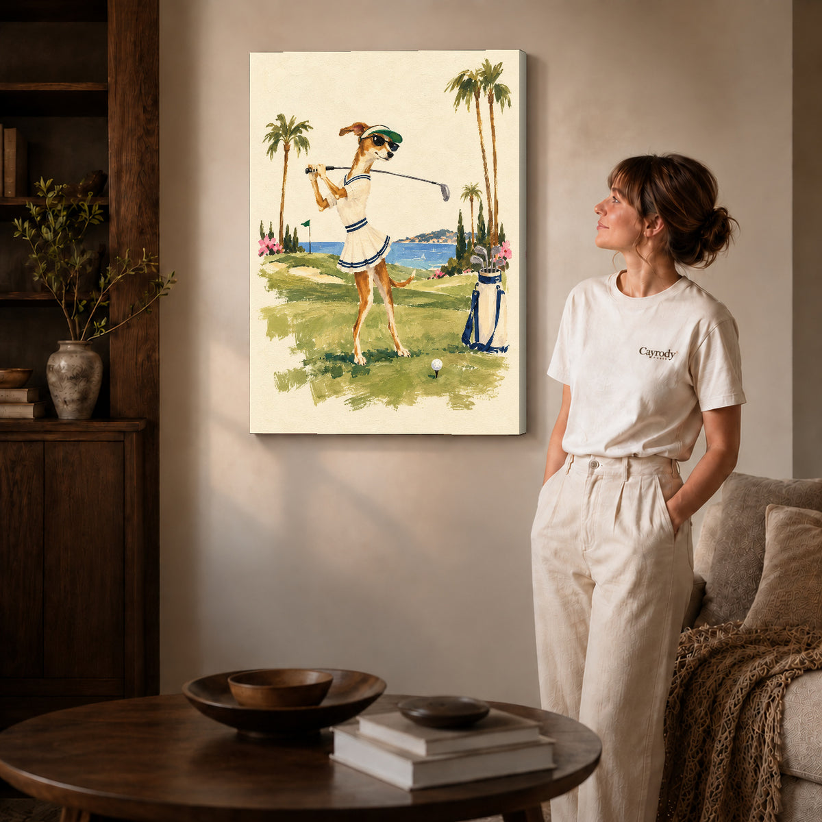 Gallery wrapped coastal golfing dog artwork with shaded canvas edges beside a woman wearing cream clothing.